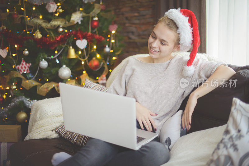 young woman in christmas interior with laptop (online dating)